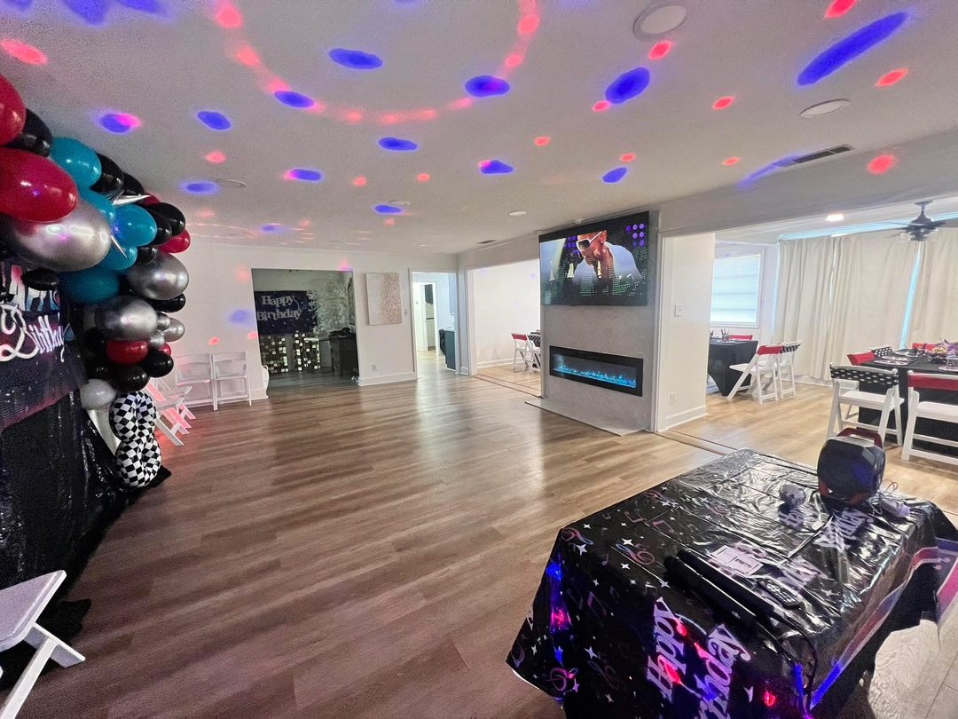 Main room with color party lighting, balloons and a birthday table